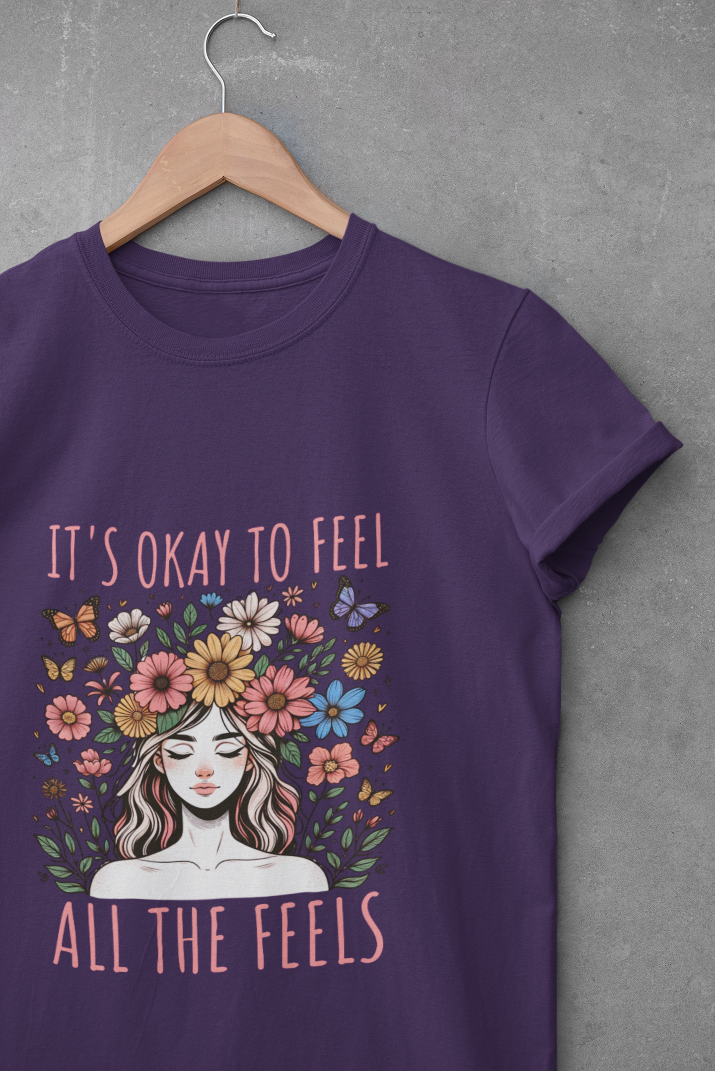 Purple t-shirt with floral crown graphic and text that reads “It’s Okay to Feel All the Feels”