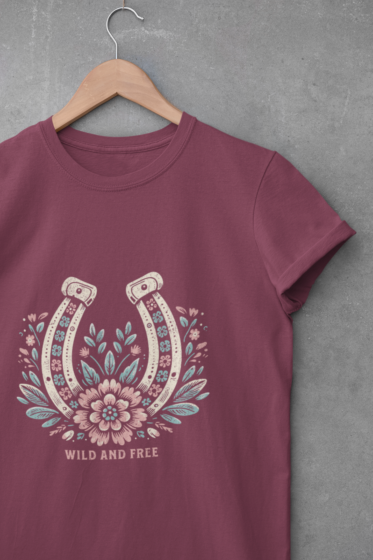 Maroon unisex t-shirt with floral horseshoe graphic and the phrase “Wild and Free”