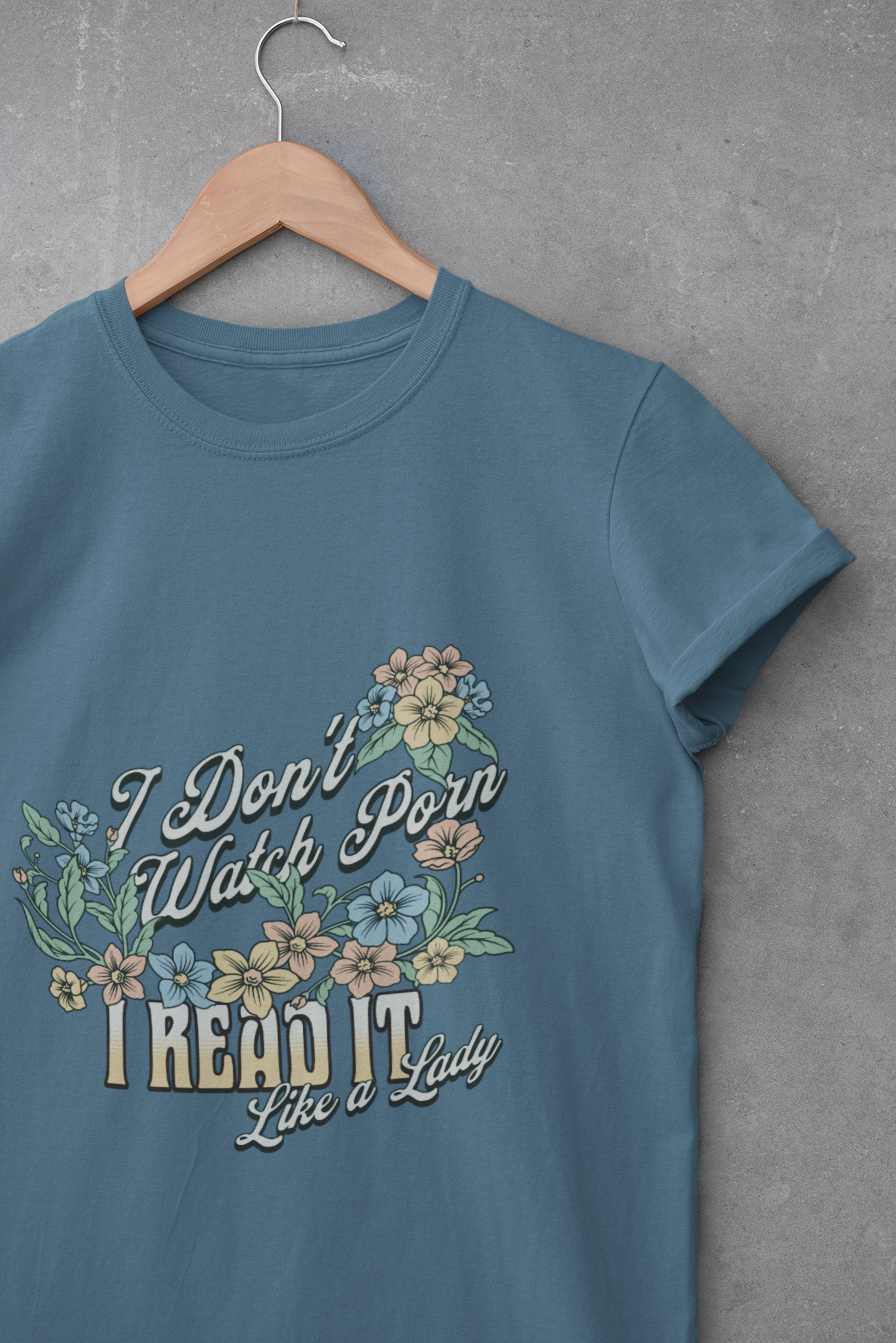 Blue unisex t-shirt with pastel floral design and the quote “I Don’t Watch Porn, I Read It Like a Lady” in vintage script