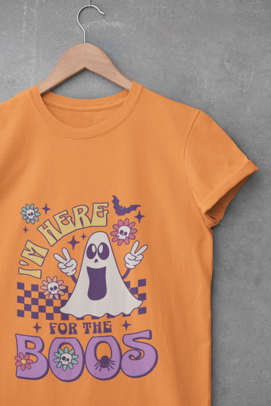 Orange t-shirt with a ghost graphic and text on a hanger against a gray background