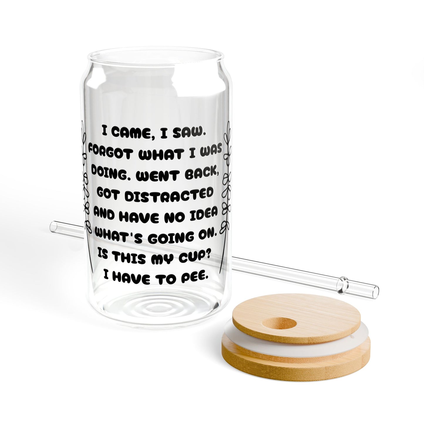 Clear glass tumbler with text, wooden lid, and white coaster on a white background