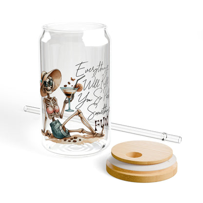 Glass tumbler with skeleton design, straw, and coasters on a white background
