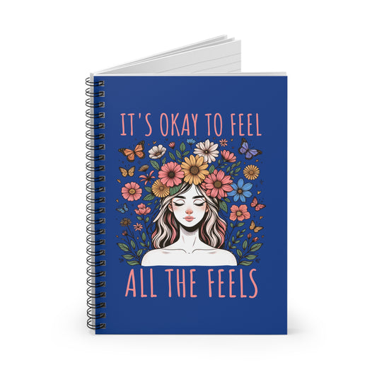 Spiral-bound floral notebook with an illustrated woman, butterflies, and the words “It’s Okay to Feel All the Feels”