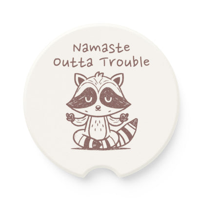 Soapstone coaster with a raccoon illustration and 'Namaste Outta Trouble' text on a white background